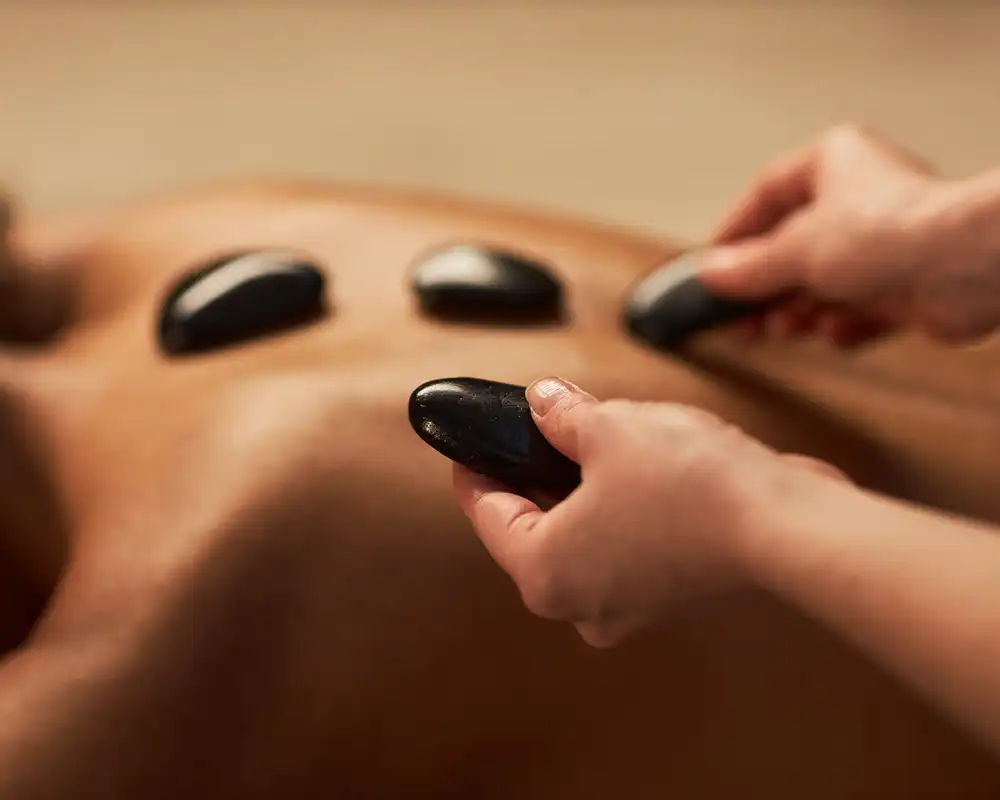 Hot stone massage with heated stones on back